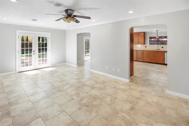 an empty room with kitchen and windows
