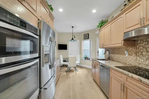 a kitchen with stainless steel appliances granite countertop a stove and white cabinets