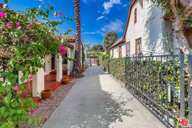a front view of a house with a yard and a trees