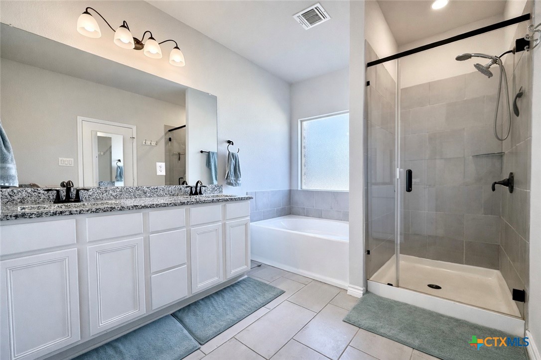 1201 Roma Street Harker Heights, TX 76548 - Photo 16 of 33 a bathroom with a tub a sink shower and mirror
