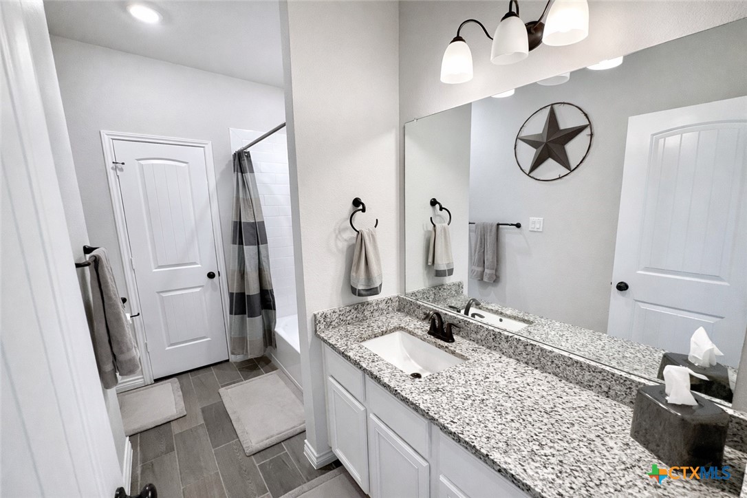1201 Roma Street Harker Heights, TX 76548 - Photo 20 of 33 a bathroom with a granite countertop sink and a mirror