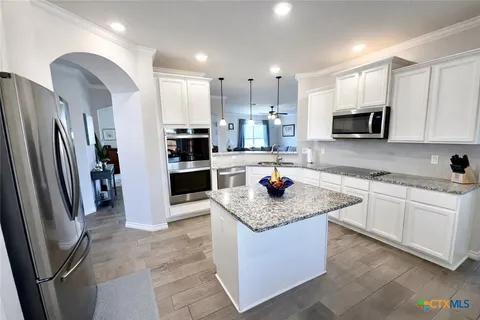 a dining room with furniture a chandelier and wooden floor