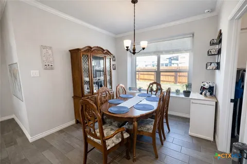 a view of a dining room and livingroom with furniture wooden floor a chandelier