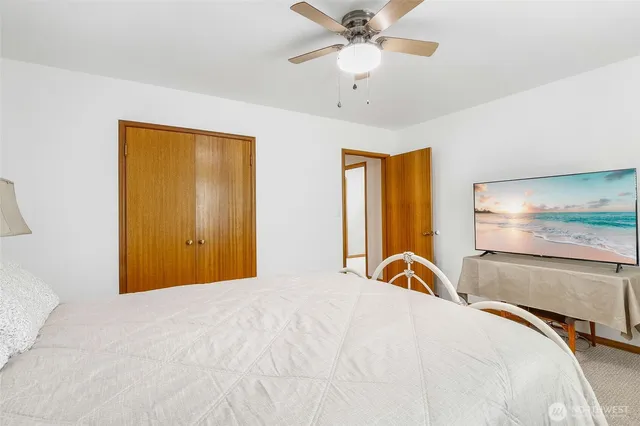 a bedroom with a bed and a large window