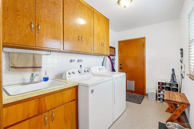 a utility room with sink dryer and washer