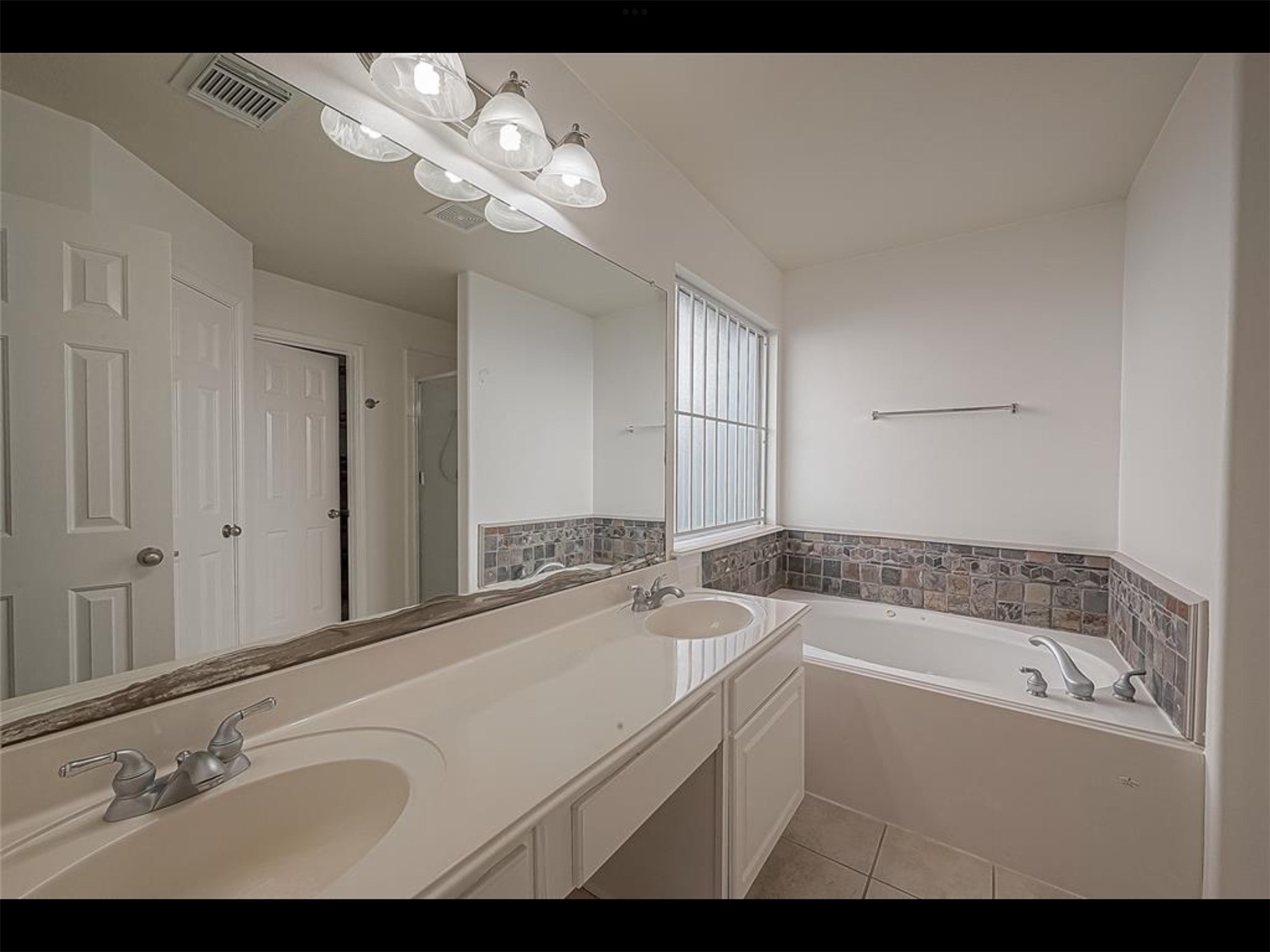 10819 Waterfern Court Houston, TX 77064 - Photo 17 of 37 a bathroom with a sink a mirror and a bathtub