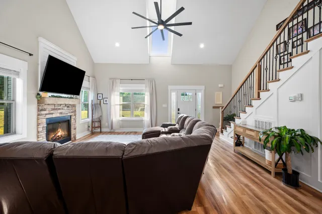 a kitchen with stainless steel appliances granite countertop a table chairs and a wooden floor