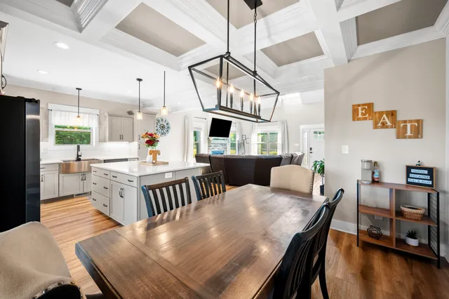 a view of a hallway with wooden floor and a bathroom
