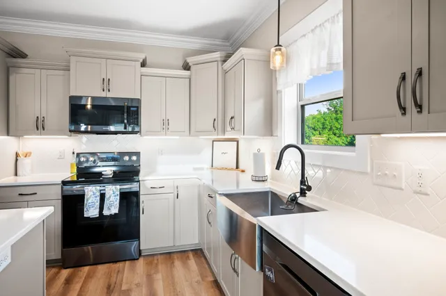 a bed room with a bed a window and a chandelier