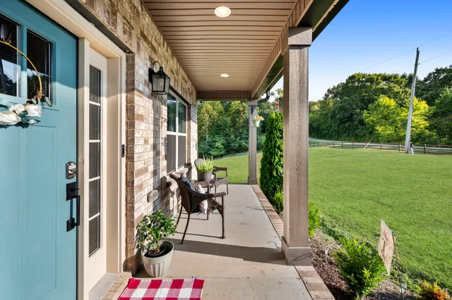 a kitchen with stainless steel appliances kitchen island granite countertop a dining table chairs and white cabinets
