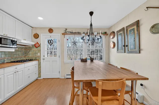 a kitchen with stainless steel appliances kitchen island granite countertop a table chairs sink and cabinets