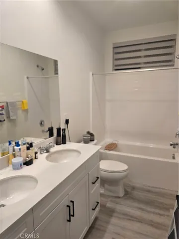 a bathroom with a double vanity sink toilet and a bathtub