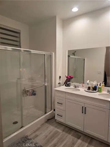 a bathroom with a double vanity sink mirror and shower