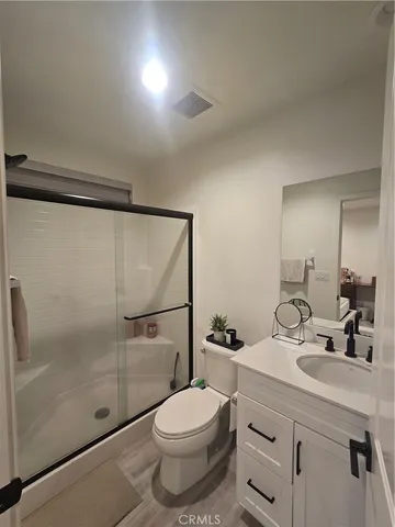 a bathroom with a shower sink vanity mirror and toilet