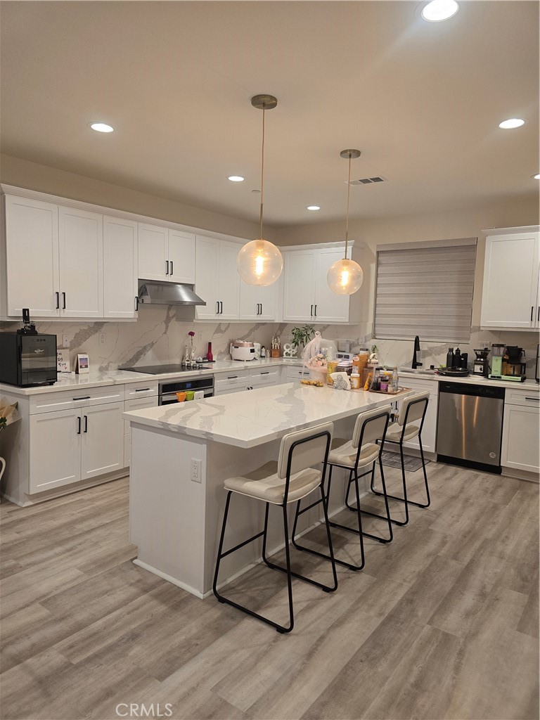 10901 Montauk Lane Stanton, CA 90680 - Photo 4 of 21 a kitchen with stainless steel appliances kitchen island granite countertop a stove a sink a refrigerator and white cabinets with wooden floor