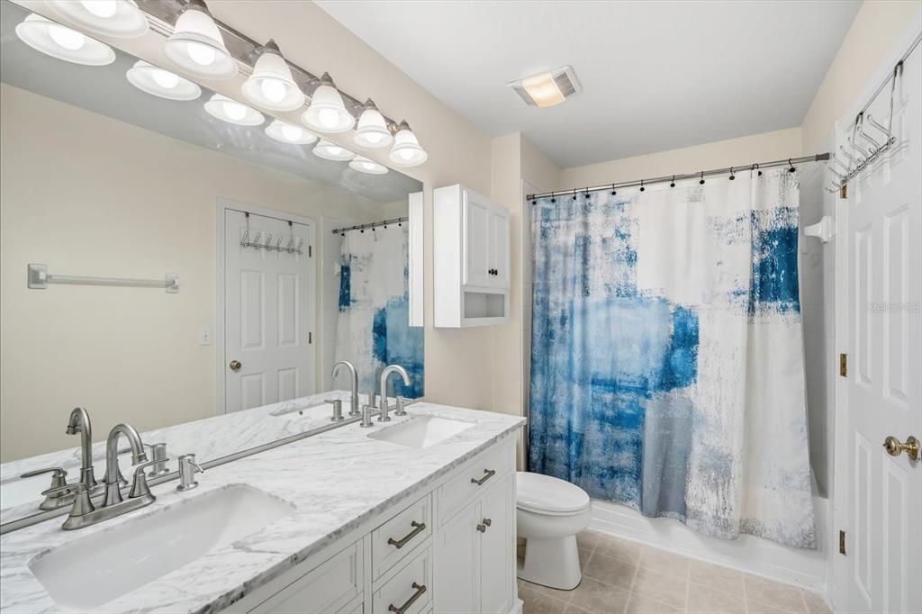 11008 Black Swan Court Seffner, FL 33584 - Photo 18 of 32 a bathroom with a granite countertop sink toilet and shower