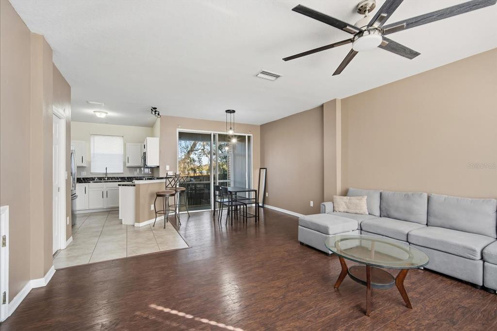 11008 Black Swan Court Seffner, FL 33584 - Photo 7 of 32 a living room with furniture kitchen view and a wooden floor
