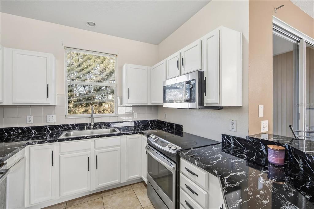 11008 Black Swan Court Seffner, FL 33584 - Photo 10 of 32 a kitchen with stainless steel appliances granite countertop a stove sink and cabinets