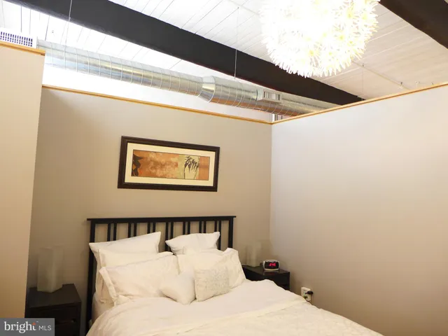 a bedroom with a bed and a painting on the wall