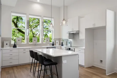 a kitchen with a table chairs sink and cabinets