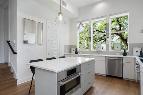 a kitchen with a stove a sink and windows