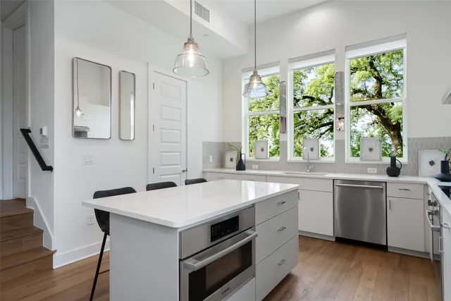a kitchen with a stove a sink and windows