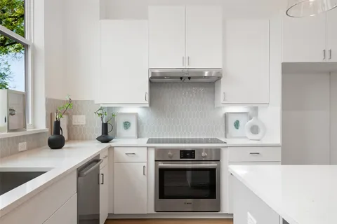 a kitchen with a stove and a white cabinets