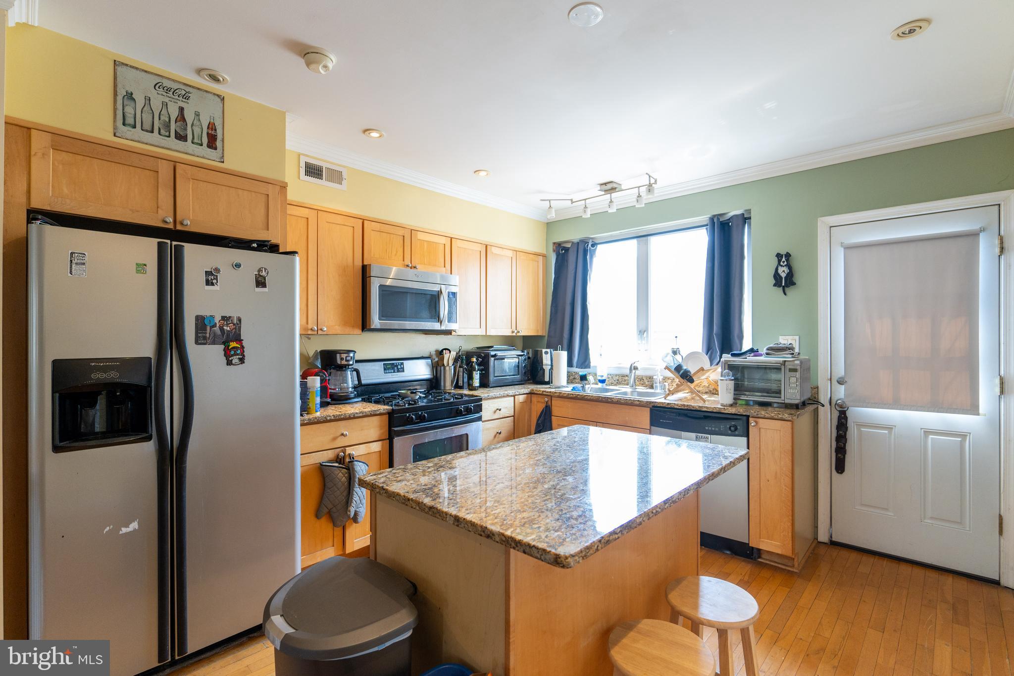 1108 Fitzwater Street Philadelphia, PA 19147 - Photo 4 of 25 a large kitchen with stainless steel appliances a refrigerator a stove a sink dishwasher and white cabinets with wooden floor