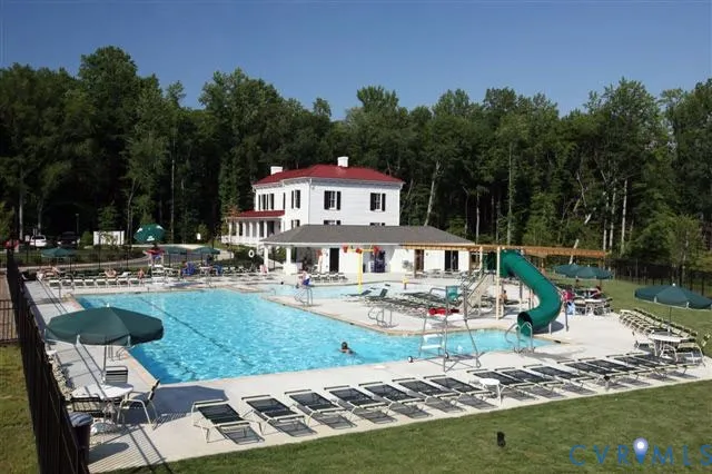 a view of a house with backyard sitting area and swimming pool