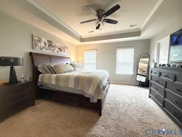a spacious bedroom with a bed a dresser and a chandelier