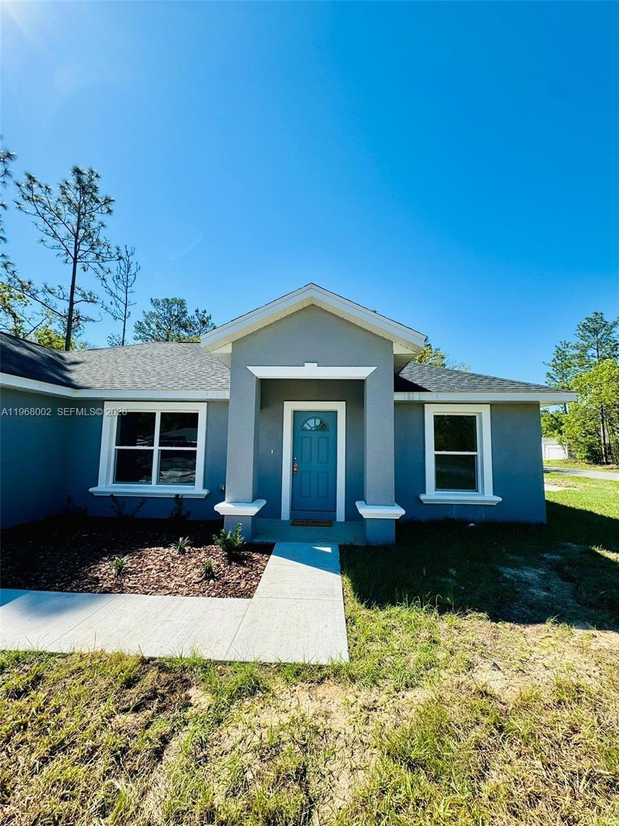 13731 Southwest 89 Circle Ocala, FL 34473 - Photo 2 of 24 a front view of a house with a yard