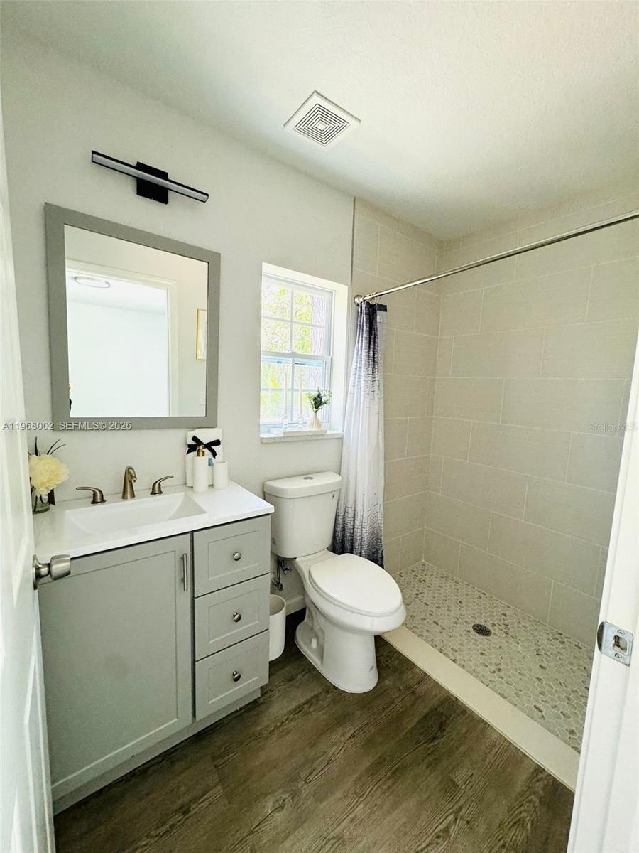 13731 Southwest 89 Circle Ocala, FL 34473 - Photo 23 of 24 a bathroom with a toilet sink a mirror a shower and vanity