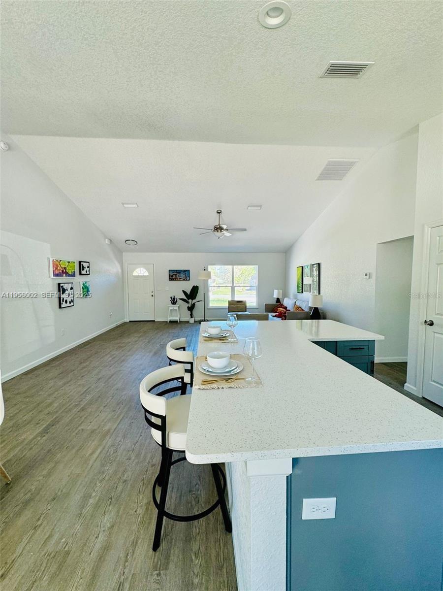 13731 Southwest 89 Circle Ocala, FL 34473 - Photo 10 of 24 a room with kitchen island a wooden floor and a sink