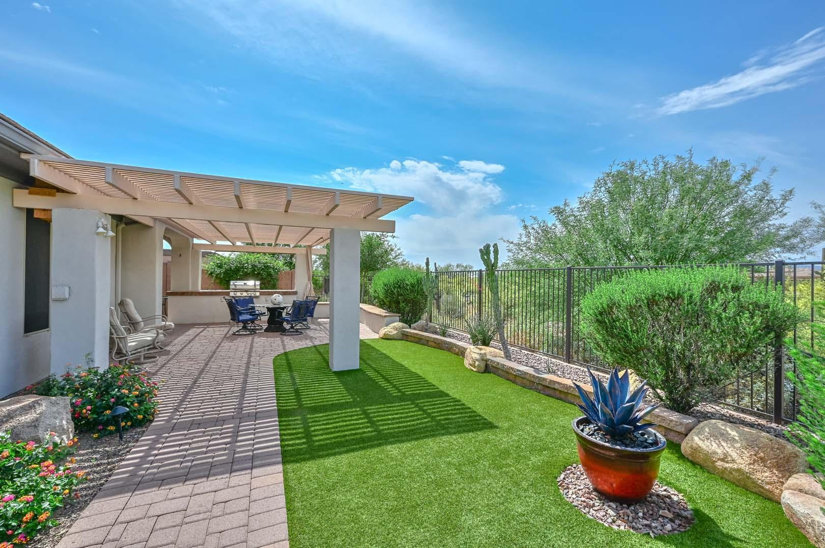 41418 North Clear Crossing Road Anthem, AZ 85086 - Photo 4 of 43 a view of a patio with couches chairs potted plants and large tree