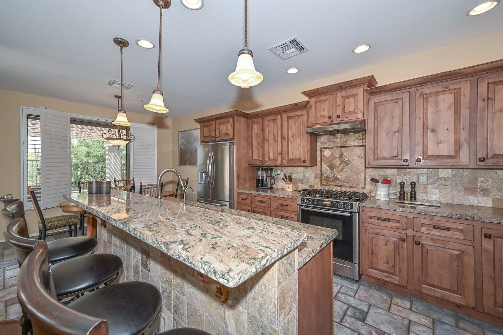 41418 North Clear Crossing Road Anthem, AZ 85086 - Photo 5 of 43 a kitchen with kitchen island granite countertop a sink stove and cabinets