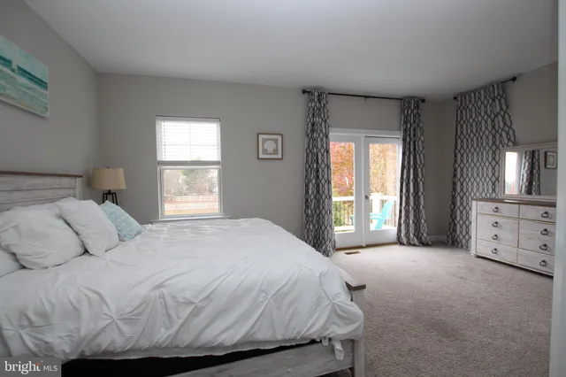 a large bed sitting in a bedroom next to a window