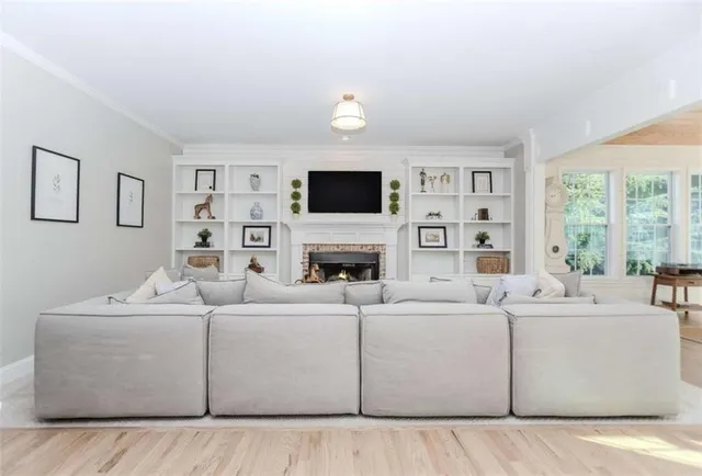 a living room with furniture a fireplace and a flat screen tv