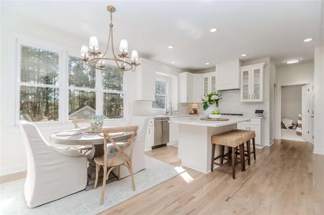 a view of a dining room with furniture a chandelier and wooden floor