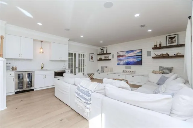 a living room with furniture white walls and kitchen view