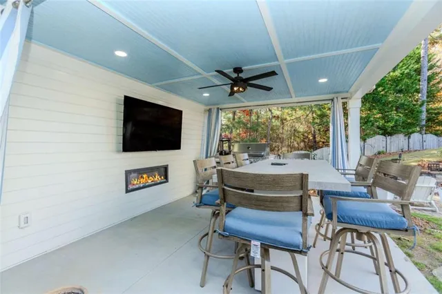 a living room with furniture a flat screen tv and a large window
