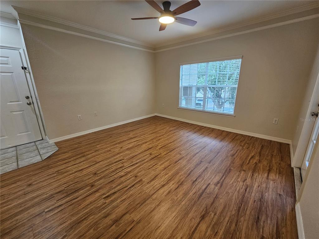 5174 Northridge Road, Unit 209 Sarasota, FL 34238 - Photo 6 of 25 an empty room with wooden floor and windows