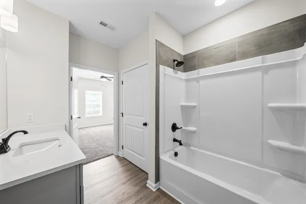 a bathroom with a sink a mirror toilet and bathtub