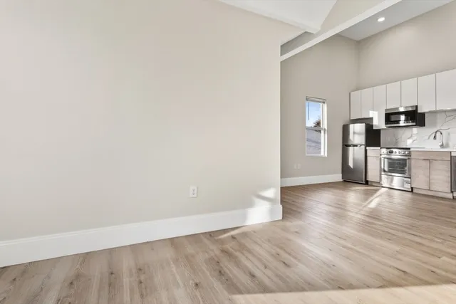 a view of a kitchen with wooden floor and electronic appliances