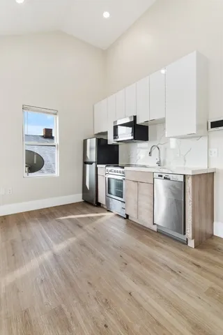 a view of a kitchen with a sink cabinets and wooden floor