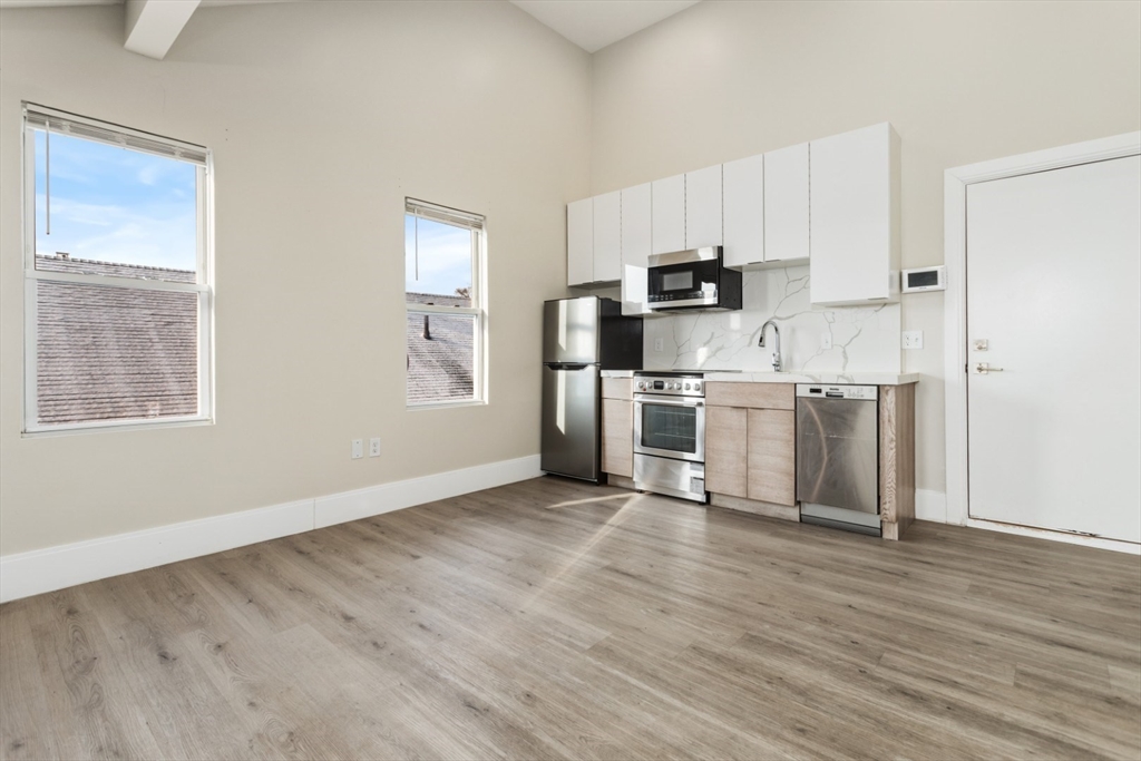 41 Wolcott Street, Unit 5 Everett, MA 02149 - Photo 13 of 22 a view of kitchen with stainless steel appliances wooden floor and window