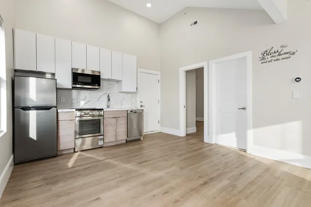 a kitchen with granite countertop a refrigerator and a stove top oven