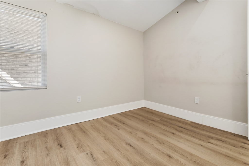 41 Wolcott Street, Unit 5 Everett, MA 02149 - Photo 8 of 22 an empty room with wooden floor and windows