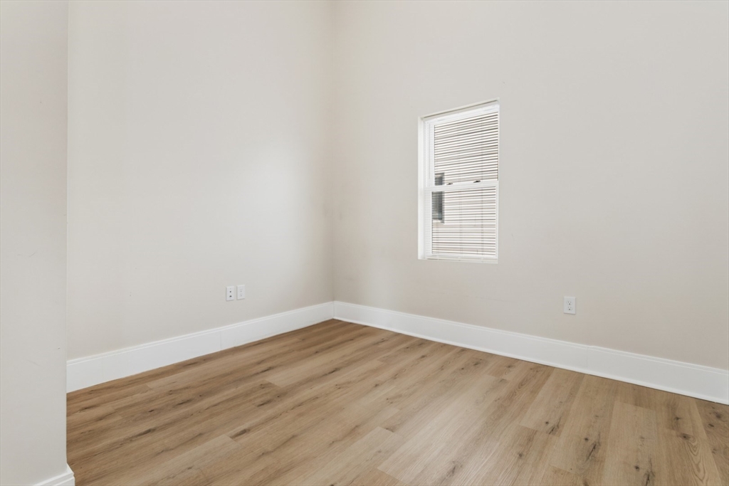 41 Wolcott Street, Unit 5 Everett, MA 02149 - Photo 9 of 22 a view of an empty room with wooden floor and a window