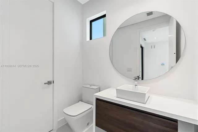 a bathroom with a toilet a sink and mirror