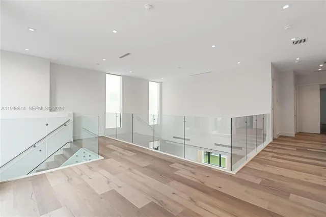 a large white kitchen with granite countertop a large window and white stainless steel appliances